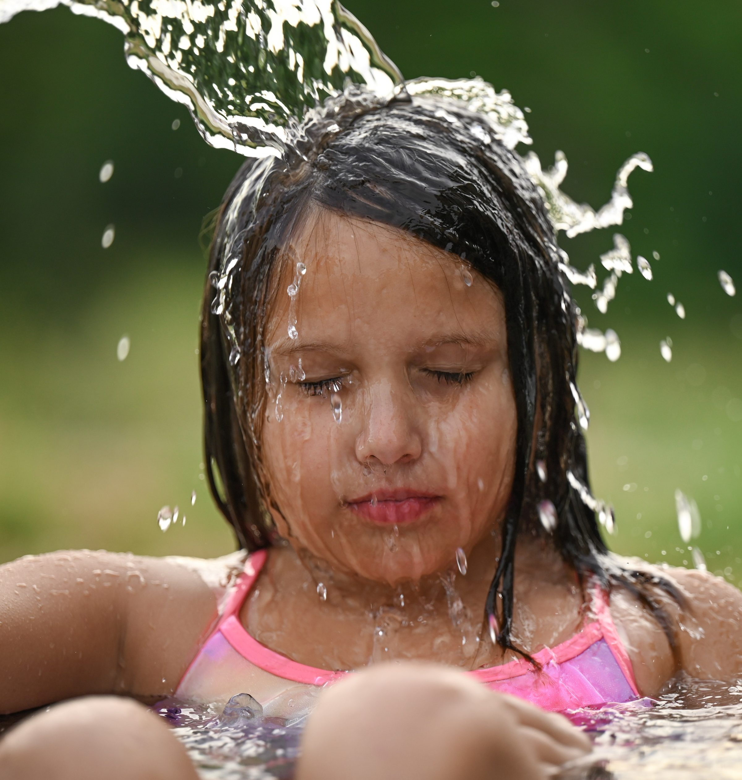 Water splashing over a child's face in golden light